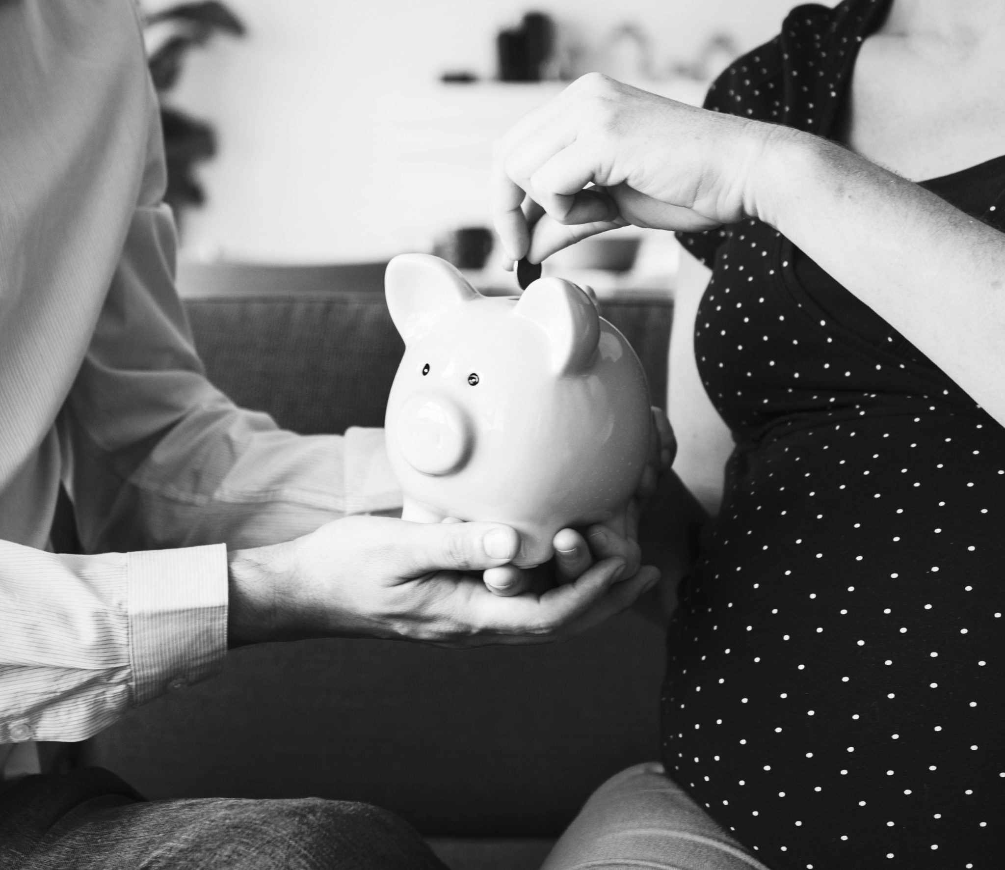 grey scale imageof a man hold piggi bank and women putting money (Basic Money Saving Tips For Housewives)