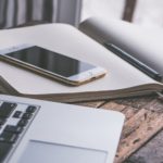 Image depicting an i-phone on a notebook beside a macbook symbolizing benefits of technology