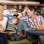 Mother looking at the watch and dad and son losing patience waiting for flight