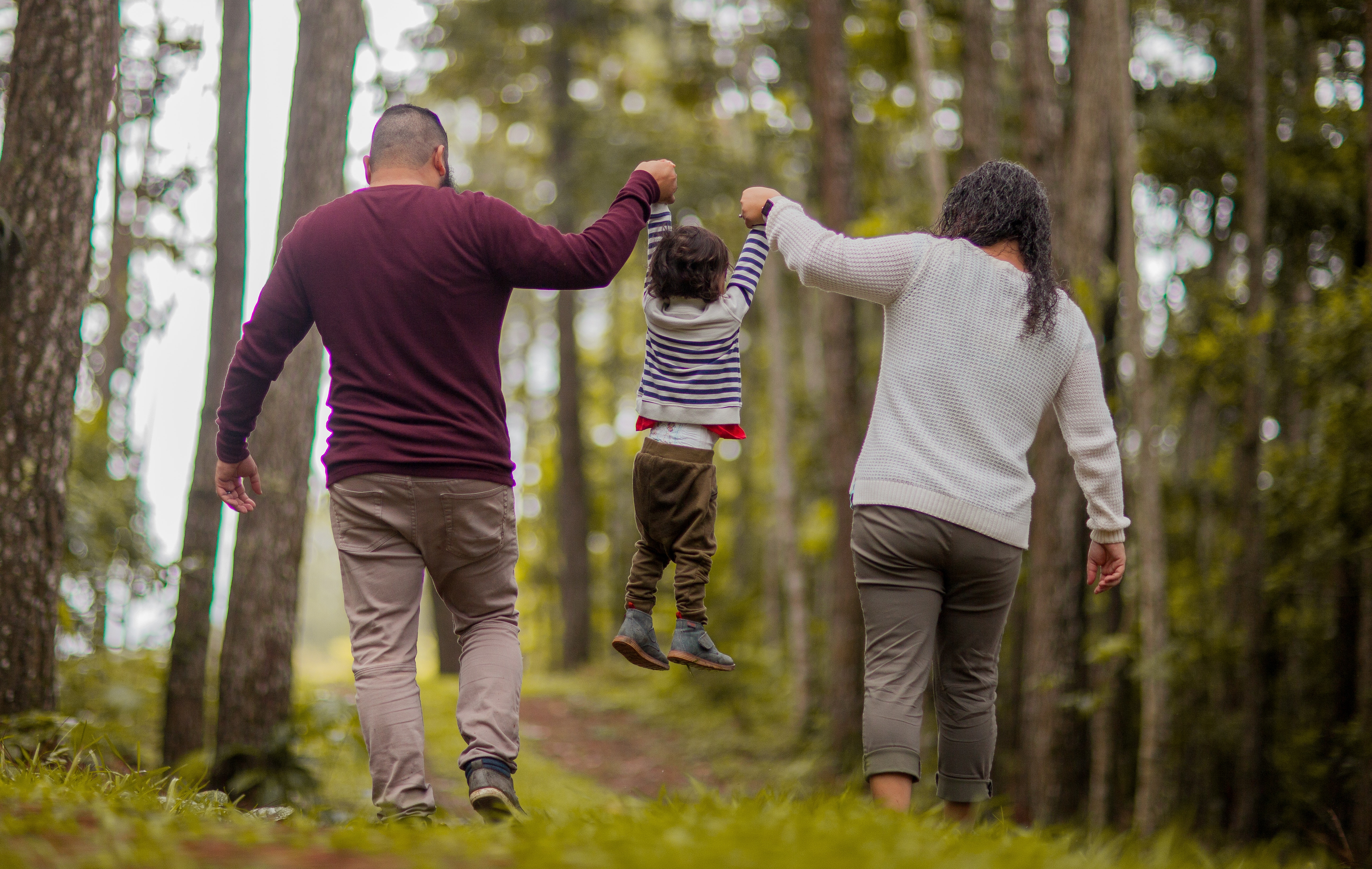 Parents in woods holding toddlers hands (Positive parenting tips for toddlers)