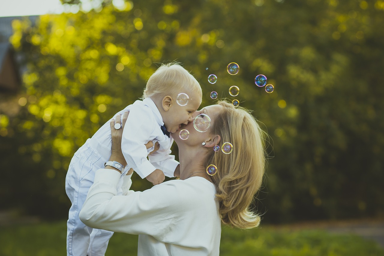 Emotional development in babies: Mother Kissing her baby